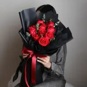 ผู้หญิงถือช่อกุหลาบวาเลนไทน์สีดำ ดอกกุหลาบสีแดง